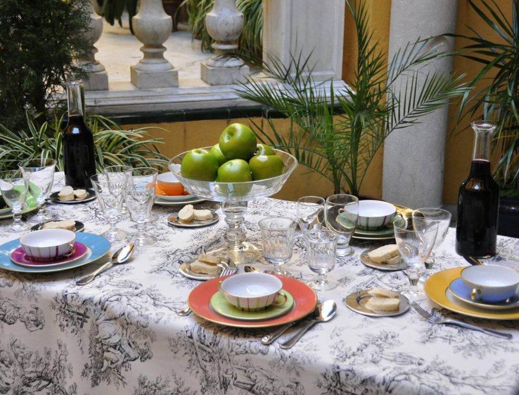 Mesa decorada con vajilla colorida y manzanas verdes para listas de boda en Sevilla